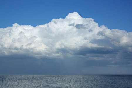 The origin of the storm is far out at sea. A huge white cloud over the dark sea. High quality photo