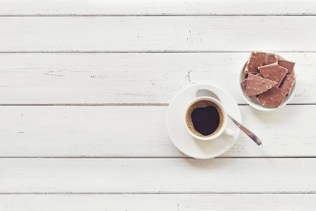 Cup of coffee with chocolate on wooden table top view