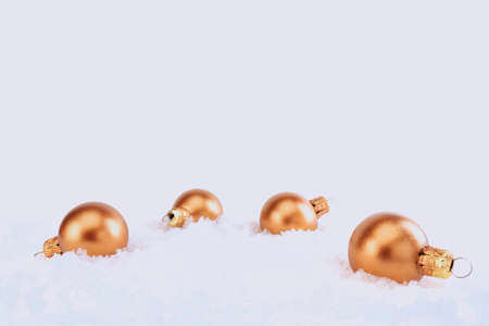 Bronze Christmas balls in the snow isolated on a white backgroundの写真素材