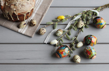 Top view to Easter table decoration with traditional cake oh the tea towel, colored eggs, quail eggs...