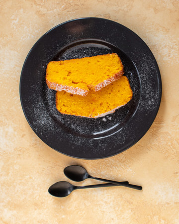 Fresh baked homemade pumpkin pie on a black ceramic plate. Bright yellow background. Close up. Top...