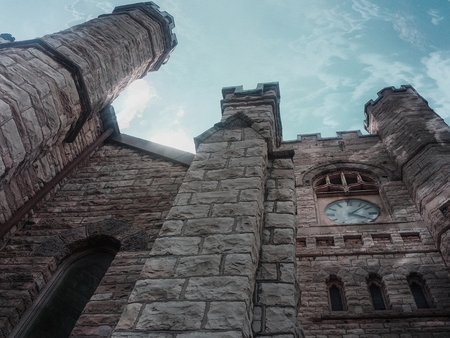White stone church walls with clock and blue skyのeditorial素材