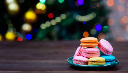 multicolored cookies macaroons lie slide on the background of the christmas treeの写真素材