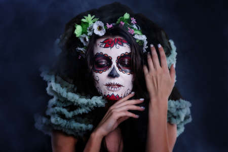 Young woman with sugar skull makeup. Dia de los muertos. Day of The Dead. Halloween costume and make-up. Portrait of Calavera Catrinaの写真素材