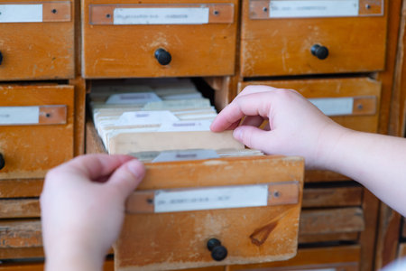Hands leafing through cards in the library catalog