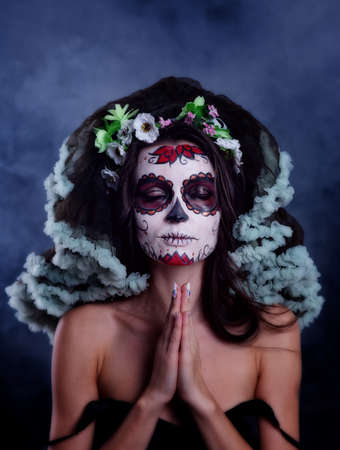 Young woman with sugar skull makeup. Dia de los muertos. Day of The Dead. Halloween costume and make-up. Portrait of Calavera Catrinaの写真素材