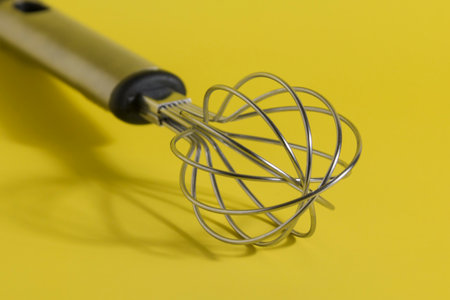 whisk on yellow background. Kitchenware.の写真素材