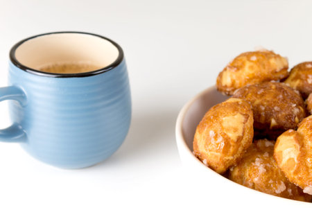 french chouquettes puffs with perles of sugar on plate with blue cup of coffee. Choux pastry Classic French bakeries.の写真素材