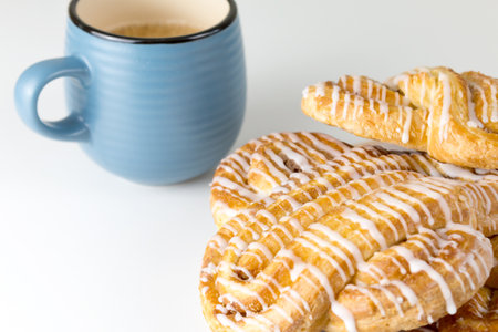 Cinnamon roll or cinnamon bun on plate with blue cup of coffee. Classic American or French bakeries.の写真素材