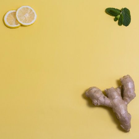 ginger with lemon slices and mint on a yellow backgroundの写真素材