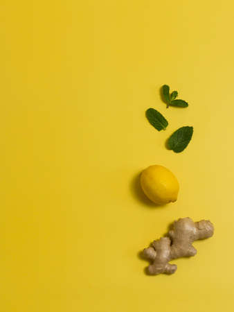 ginger with lemon and mint on a yellow backgroundの写真素材