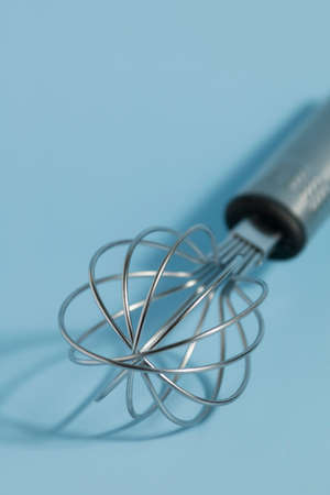whisk metal on blue background. Close up.の写真素材
