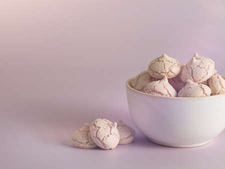 meringues in a bowl on a pink backgroundの写真素材
