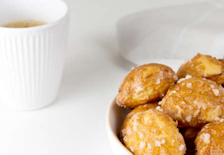 french chouquettes puffs with perles of sugar on plate with white cup of coffee. Choux pastry Classic French bakeries.の写真素材