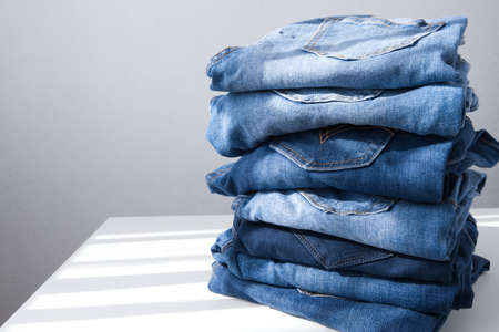 a pile of blue jeans on a light background. Close up. Copy space. Sunlightの写真素材