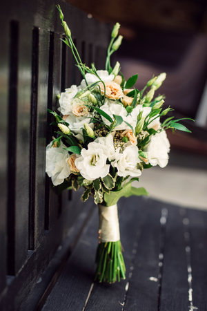 The brides bouquet is placed vertically on a black bench. Close-up. Pastel colors.の写真素材