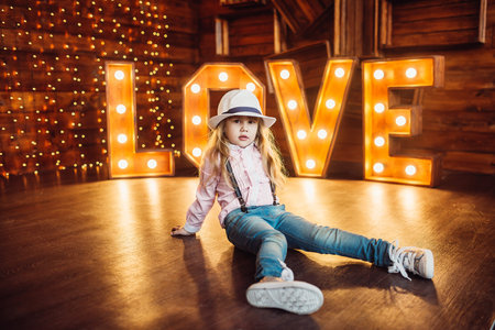 A girl wearing a hat. Portrait. Smile. Decorated Letters Love