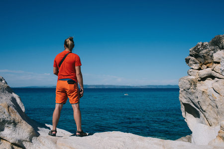 A man standing next to a body of waterの写真素材