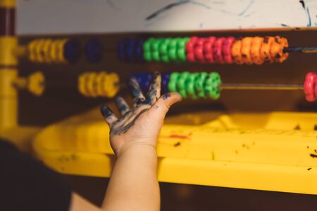 Little girl sits on the floor and draws on an easelの写真素材