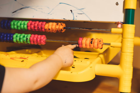 Little girl sits on the floor and draws on an easel