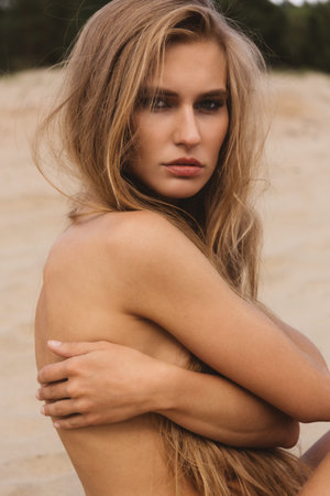 Nude portrait of a girl in underwear on the sandの写真素材