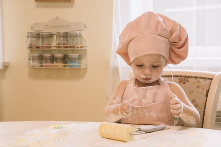 Little girl cooks at home in the kitchenの写真素材