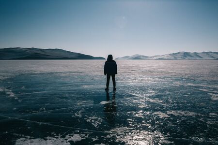 A person standing next to an ice waterfall caveの写真素材