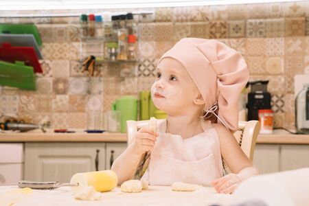 Little girl cooks at home in the kitchenの写真素材