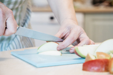 A person cutting a piece of apple on a table