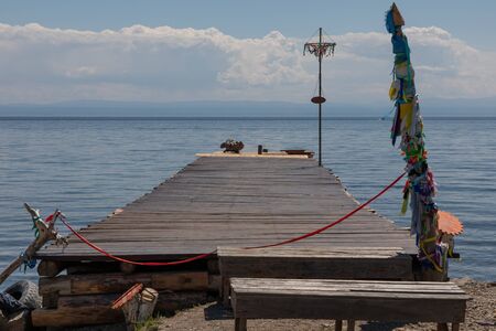 Pier with shaman ribbons against the skyline of Lake Baikalの写真素材
