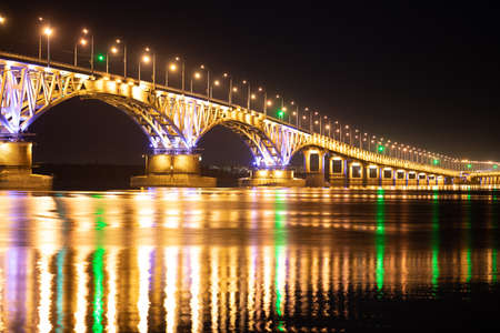 The bridge across the river glows at nightの写真素材