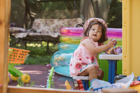 Little girl playing on the playground in the yardの写真素材