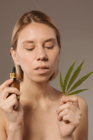 CBD cosmetics concept. Beautiful woman with a cannabis leafの写真素材