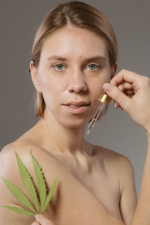 CBD cosmetics concept. Beautiful woman with a cannabis leafの写真素材