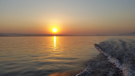 Dawn on the boat while driving the spray from the motorの写真素材