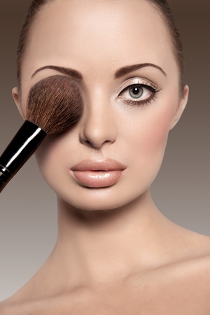 Portrait of a beautiful woman with a make up brushの写真素材