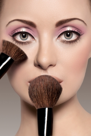 Portrait of a beautiful woman with a make up brushの写真素材