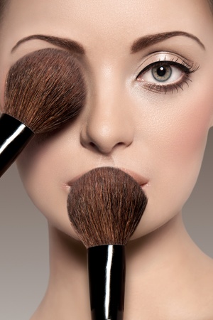 Portrait of a beautiful woman with a make up brushの写真素材