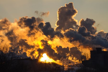 Power plant with smoke and dirty orange airの写真素材