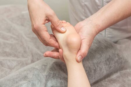 masseur doing leg massage for a happy childの写真素材