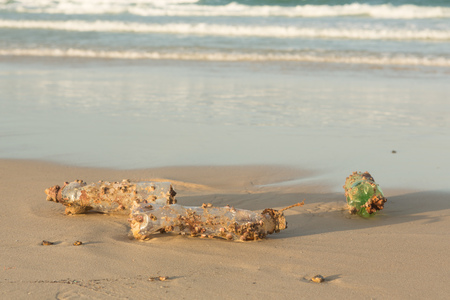 Plastic products clog nature more and more. Plastic bottle covered in sea barnacles and sponges (foulers) and cast ashore on the beach, marine pollution.の写真素材