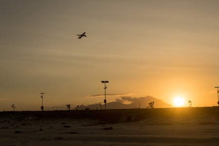 Silhouette of a plane taking off from the airport at sunset airportの写真素材