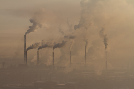 Power plant with smoke and dirty orange airの写真素材