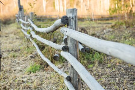 rural wooden fence. natural autumn background at sunsetの写真素材