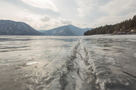 View of beautiful drawings on ice from cracks and bubbles of deep gas on the surface of lake...