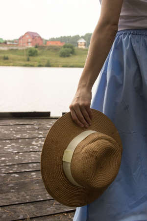 women's straw hat, hold in hand in summer.の写真素材