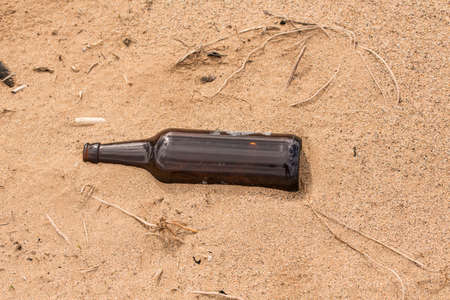 Someone left an empty bottle on the sand instead of recycled it.の写真素材