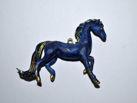 Small pendant in the form of blue and gold hourseの写真素材