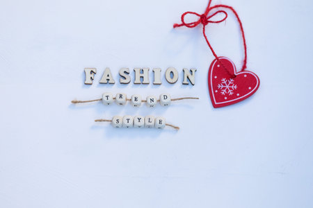 Fashion Winter Mood Concept. Red Heart Christmas Tree Decoration and Words Fashion, Trend, Style are...