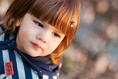 Cute boy spring portrait, flower in hair, looking far awayの写真素材